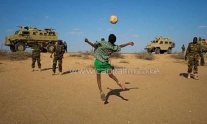 Somali boy plays with AMISOM soldiers in Buur-Hakba. Photo/ AMISOM