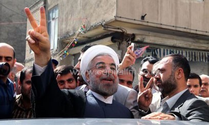 Iranian moderate presidential candidate, Hassan Rowhani flashes the sign of victory as he leaves a polling station after voting on June 14, 2013 in Tehran/AFP
