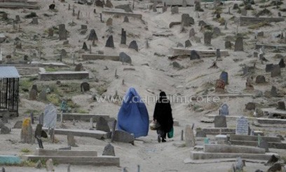 Burqa-clad Afghan women walk through a graveyard in the old section of Kabul on May 25, 2011. A bomb killed 14 women and children at a graveyard in eastern Afghanistan on Thursday as the country celebrated the Eid al-Fitr holiday marking the end of Ramadan, officials said/AFP
