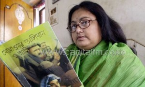 Sushmita Banerjee holds one of her Bengali language novels during press conference in Kolkata, on March 6, 2013/AFP