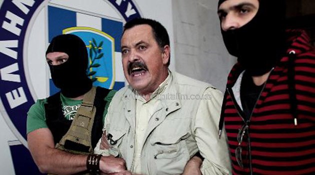 Christos Pappas, lawmaker of the extreme far-right Golden Dawn party, is escorted by masked police officers to the prosecutor's office from police headquarters in Athens on September 29, 2013/AFP