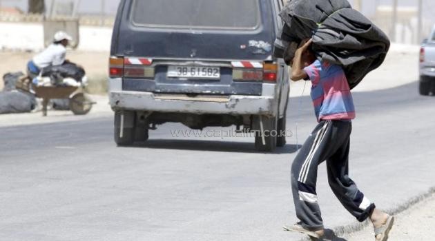 A Syrian refugee boy carries blankets through the Zaatari refugee camp, located close to the Jordanian city of Mafraq, near the border with Syria, on September 4, 2013/AFP