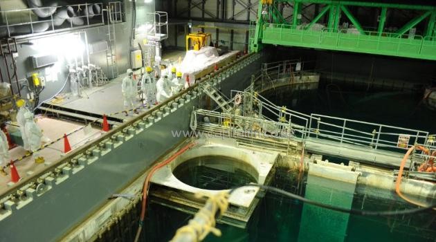 This photo, taken by Tokyo Electric Power Co (TEPCO) on November 13, 2013, shows US nuclear expert Lake Barrett and TEPCO workers inspecting the spent fuel pool at the unit four reactor building of the crippled Fukushima Dai-ichi nuclear plant/AFP