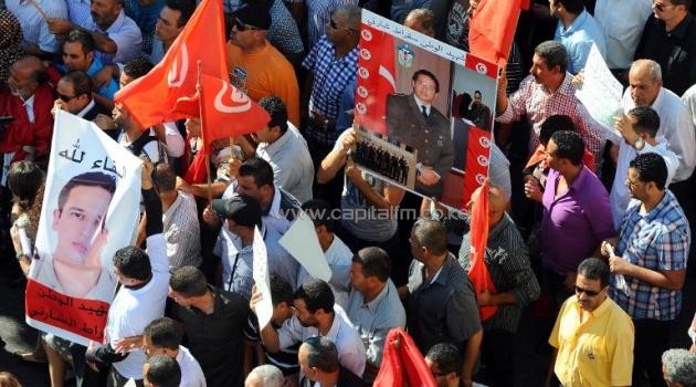 Tunisians hold portraits and national flags during a demonstration organized by unions outside the interior ministry on October 28, 2013/AFP