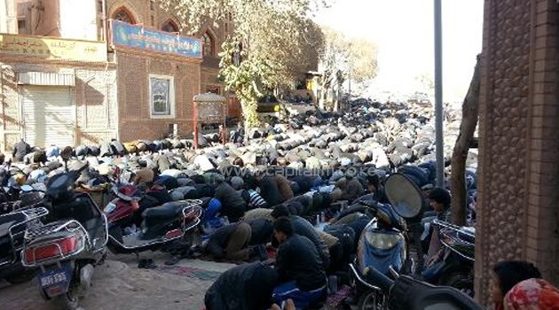 A group gathers to pray outside a mosque in China's Xinjiang region, on November 8, 2013/AFP