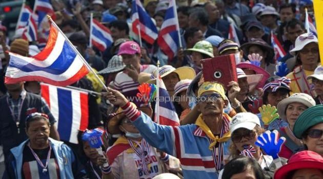 Thai anti-government protesters wave national flags during a rally in Bangkok on 17 January 17 2014/AFP