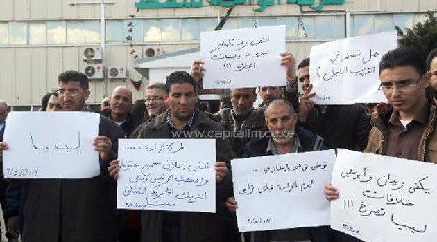 Company employees picket outside the Oasis Libyan Oil headquarters in Tripoli after the government threatened to bomb a North Norean-flagged tanker, which is suspected of trying to load an illegal oil, at its Al-Sidra oil terminal, on March 9, 2014/AFP