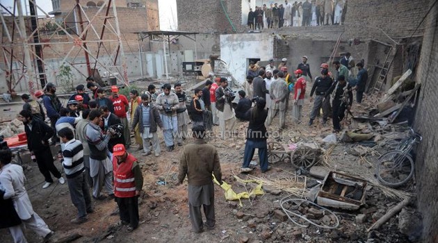 Pakistani security and media personnel gather at the site of a bomb explosion on the outskirts of Peshawar on January 23, 2014/AFP