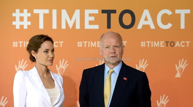 Britain's Foreign Secretary William Hague and US actress and campaigner Angelina Jolie pose for pictures upon arrival to co-host the four-day Global Summit to End Sexual Violence in Conflict in east London on June 10, 2014/AFP