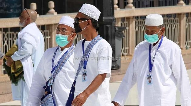 Undeterred by the spread of the MERS virus in Saudi Arabia, Muslim pilgrims wear masks on their way to Islam's holiest shrine, the Kaaba, in the Grand Mosque of Mecca on May 27, 2014/AFP