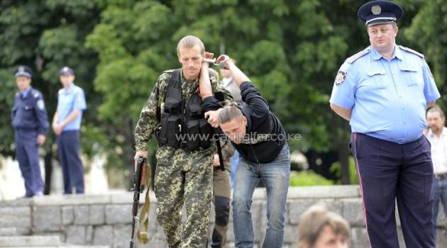 A pro-Russian militant detains a man suspected of spying for Ukraine in the eastern Ukrainian city of Donetsk on June 21, 2014/AFP