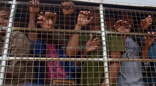 Cambodian migrant workers who crossed the border carry wait to get out of a truck upon their arrival in Poipet on June 17, 2014/AFP