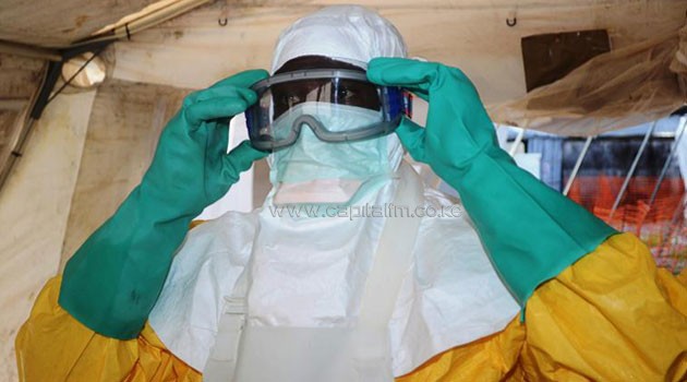 A health worker with Doctors Without Borders (MSF) puts on protective gear at an Ebola isolation ward in Conakry, on June 28, 2014/AFP