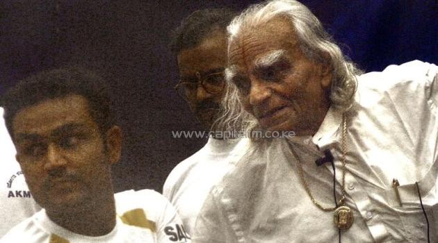 Indian yoga exponent BKS Iyengar (R) demonstrates a stretching exercise to Indian cricketer Virender Sehwag during a training camp in Bangalore, southern India, on September 3, 2003/AFP