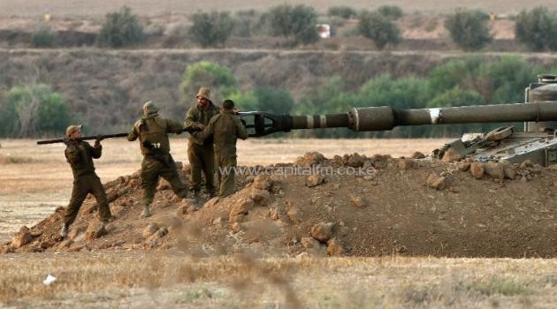 Israeli soldiers clean a 155mm artillery gun barrel at an army deployment area near the border with the Gaza Strip, on July 31, 2014/AFP