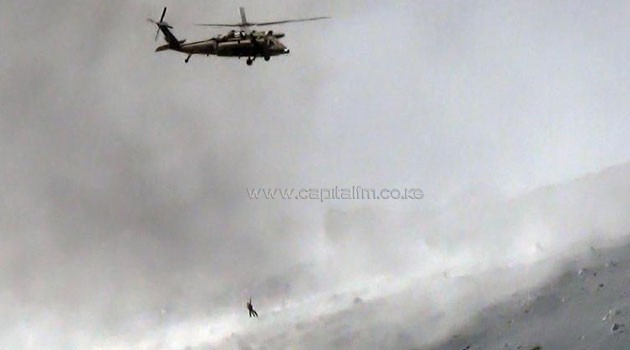 This aerial picture taken on September 28, 2014 shows a helicopter of Japan's Self Defence Force lifting a survivor from the volcanic ash covered top of Mount Ontake, one day after it erupted/AFP