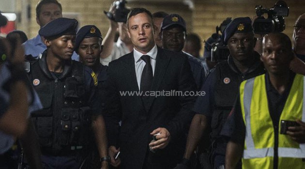South African Paralympic athlete Oscar Pistorius (centre) arrives at the High Court in Pretoria on October 21, 2014/AFP