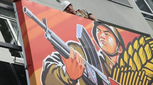 Workers remove a poster for "The Interview" from a billboard in Hollywood, California, December 18, 2014/AFP