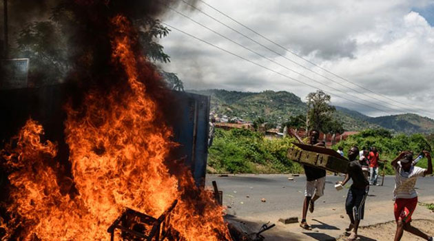 People burn mattresses looted from the local police post in Bujumbura during a protest against incumbent President Pierre Nkurunziza's bid for a thrd term, on May 13, 2015/AFP
