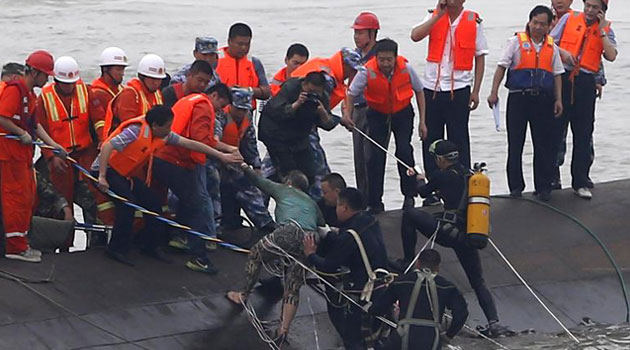 A survivor (C-green top) is rescued by divers from the Dongfangzhixing or "Eastern Star" vessel which sank in the Yangtze river in Jianli, central China's Hubei province on June 2, 2015/AFP