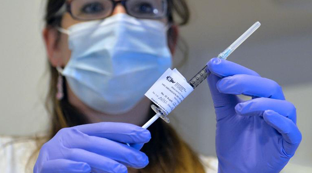 A doctor examining an ebola vaccine/FILE