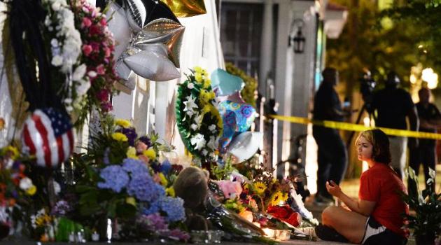 A young girl pays her respects to the victims of a gun massacre outside Emanuel AME Church in Charleston, South Carolina on June 18, 201/AFP  