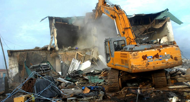 A bulldozer demolishes illegal constructions in Old Fadama slum in Accra/AFP