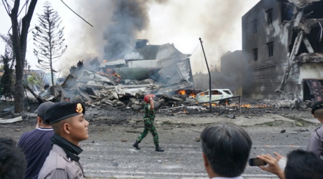 Indonesian police and military officials secure the crash site of a Hercules plane in Medan, North Sumatra province on June 30, 2015/AFP  