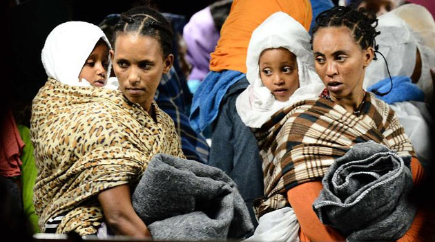 Migrants and their children wait to disembark from the "Phoenix" ship upon their arrival in the port of Augusta on the eastern coast of Sicily on June 7, 2015/FILE