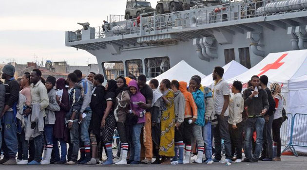 Migrants queue after disembarking from the Royal Navy ship HMS "Bulwark" upon their arrival in the port of Catania on the coast of Sicily on June 8, 2015 © AFP