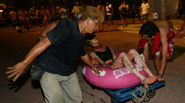 People tend to an injured woman at the Formosa Fun Coast amusement park after an explosion in the Pali district of New Taipei City on June 27, 2015/AFP