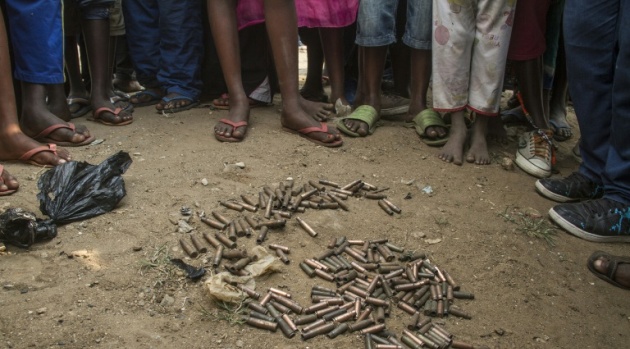 People stand around a cluster of empty cartridges lying on the ground in the Jabe distirct of Bujumbura on June 28, 2015 after a night of intense shooting that saw a young man allegedly killed by police/AFP 