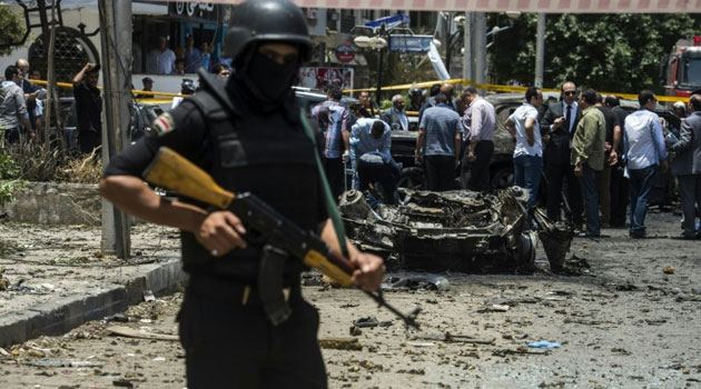 A member of the Egyptian security forces stands guard as people gather at the site of a bomb that targeted the convoy of Egyptian state prosecutor, Hisham Barakat, in the capital Cairo on June 29, 2015  © AFP/File