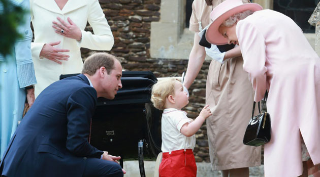 Prince George talks to his great-grandmother Queen Elizabeth after the christening of his sister Princess Charlotte at St. Mary Magdalene Church in Sandringham, on July 5, 2015/AFP