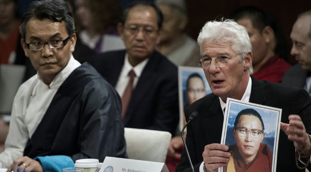 US actor Richard Gere (R) holds a photo of Tibetan monk Tenzin Delek Rinpoche, who died in a Chinese prison, before the Tom Lantos Human Rights Commission hearing, July 14, 2015 on Capitol Hill in Washington, DC/AFP