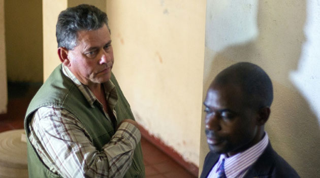 Professional Zimbabwean hunter Theo Bronkhorst (L) and his defence lawyer wait outside the Magistrate's Court in Hwange on July 29, 2015/AFP