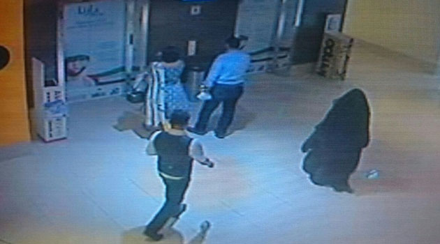 A fully veiled woman (R), the suspect in the killing of an American teacher in a shopping mall toilet, is shown walking through the mall in the Emirati capital in this CCTV image released by Abu Dhabi police on December 3, 2014/AFP