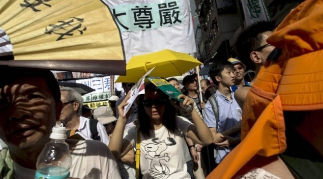 A pro-democracy protester holds a yellow umbrella, the symbol of the Occupy Central movement, during a march to demand universal suffrage in Hong Kong, China, July 1, 2015/AFP