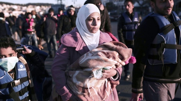 A migrant from Syria holds her child upon arrival in Greece, on Lesbos island, in April 2015/AFP  