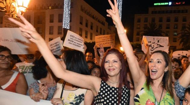 Moroccans shout slogans and hold placards during a demonstration in Rabat on July 6, 2015, against the arrest of two Moroccan women after their outfits were deemed inappropriate as they strolled through an open-air market in the city of Agadir/AFP