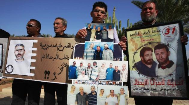 Palestinians hold portraits of jailed relatives during a protest calling for their release from Israeli prisons /AFP 