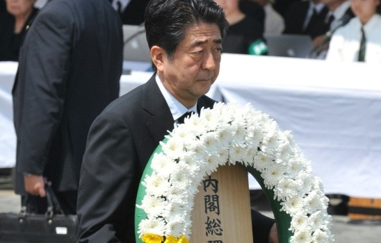 Japanese Prime Minister Shinzo Abe offers a wreath of flowers during the memorial ceremony to mark the 70th anniversary of the atomic bombing of Nagasaki on August 9, 2015/AFP  