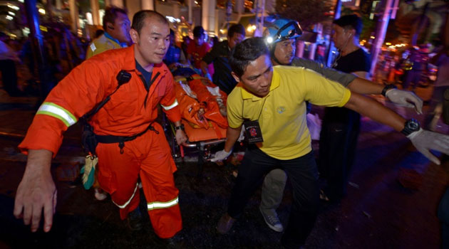 Thai rescue workers carry an injured person after a bomb exploded outside a religious shrine in central Bangkok late on August 17, 2015/AFP