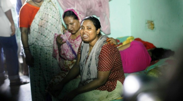 The wife (R) of murdered Bangladeshi blogger Niloy Chakrabarti, who used the pen-name Niloy Neel, weeps at their home in Dhaka on August 7, 2015/AFP