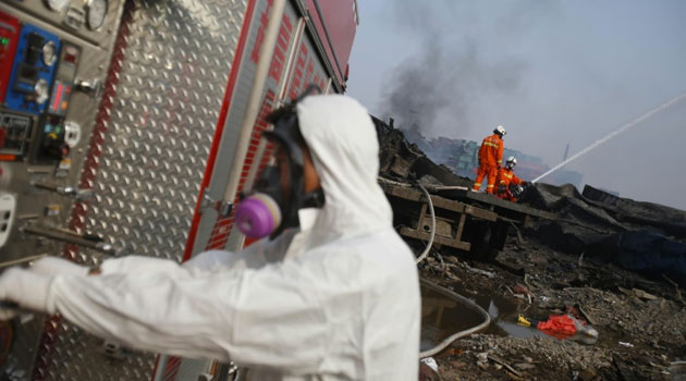 Firefighters work at the site of explosions in Tianjin, north-east China, on August 15, 2015/AFP