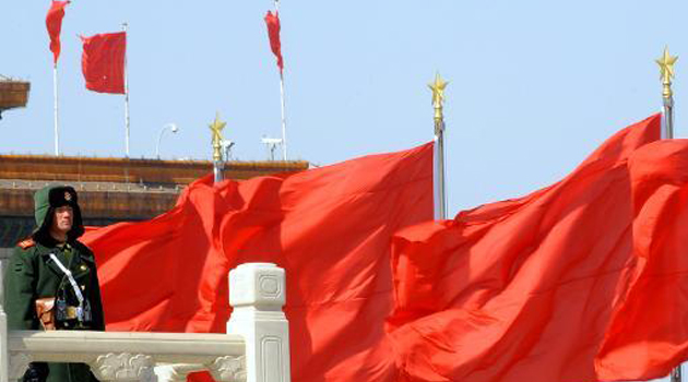 Chinese officers next to country's flag/FILE