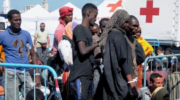 Migrants wait in Catania harbour after being rescued by the Italian coast guard on August 26, 2015 while as 50 bodies were found in the hold of a boat heading for Italy/AFP