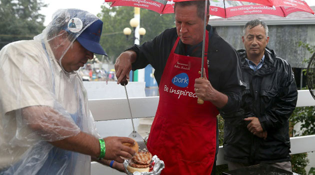 Republican presidential candidate and Ohio Governor John Kasich (R) works the grill at the Iowa Pork Producers Pork Tent during the Iowa State Fair on August 18, 2015 in Des Moines, Iowa/AFP