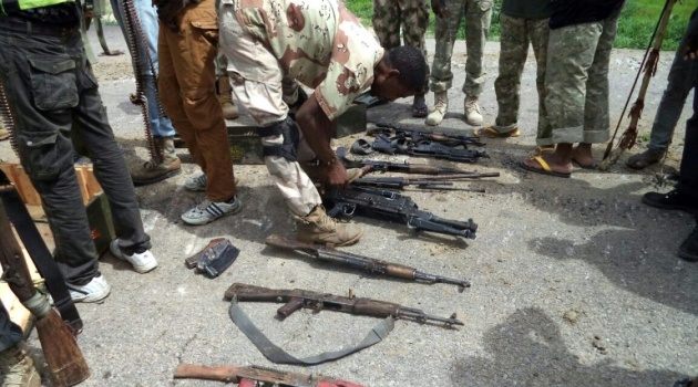 Picture taken on July 26, 2015 and released by the Nigerian Army shows a soldier inspecting weapons seized from Islamist Boko Haram fighters following clashes in the town of Dikwa, northeastern Nigeria/AFP  