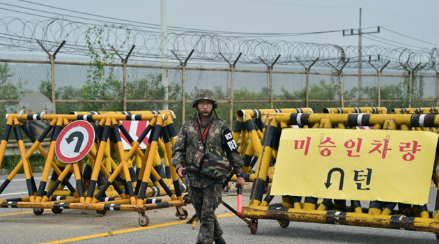 A South Korean soldier walks by barricades on the road leading to North Korea's Kaesong joint industrial complex at a military checkpoint in the border city of Paju on August 21, 2015/AFP